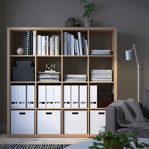Estantería KALLAX con libros, plantas y cajas de almacenamiento.