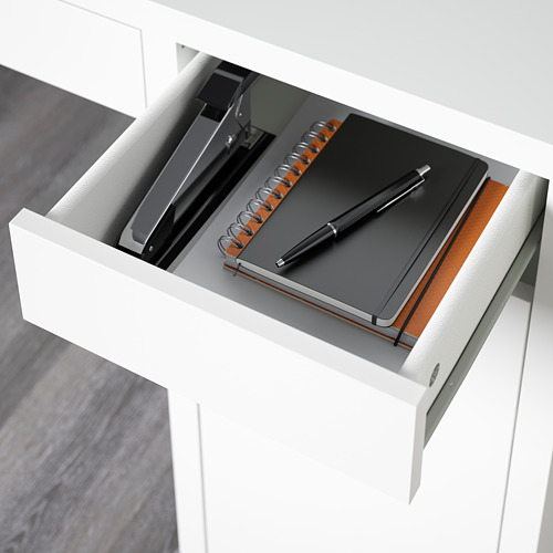 Cajón de escritorio abierto con cuaderno, bolígrafo y artículos de papelería, con estantes ajustables y salida de cables.