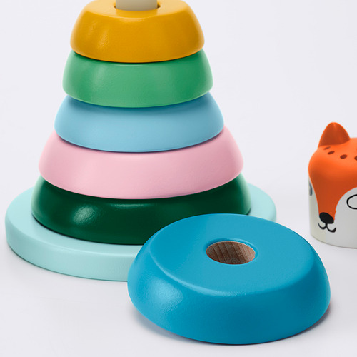 Anillos apilables de plástico brillantes y duraderos en colores pastel, colocados cuidadosamente con un anillo a un lado, que muestran calidad y diseño para el juego de los niños.