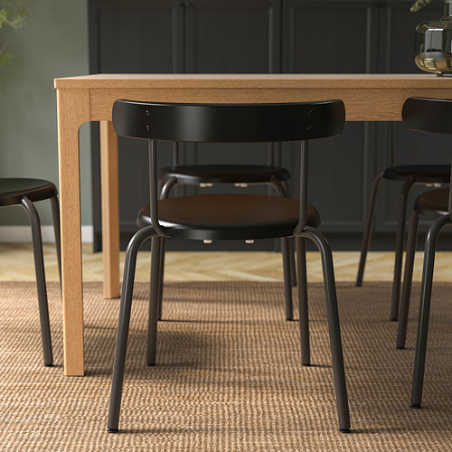 Silla de comedor moderna con respaldo redondeado, fácil de apilar y colgar en la mesa, ideal para una fácil limpieza y un uso eficiente del espacio.