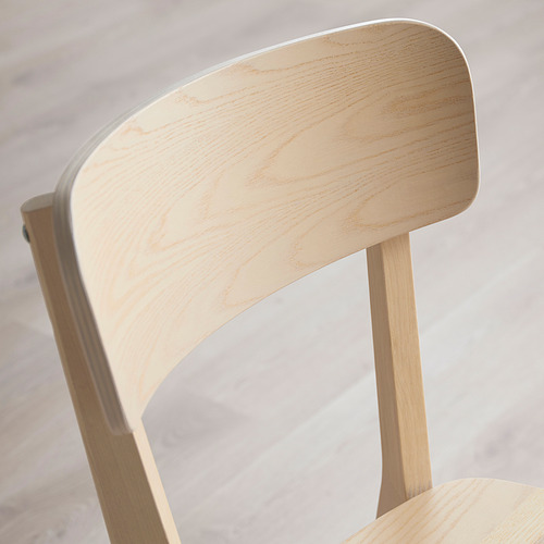 Silla de madera lisa y ligera con un elegante respaldo curvo y patas robustas, con vetas naturales y acabado pulido.