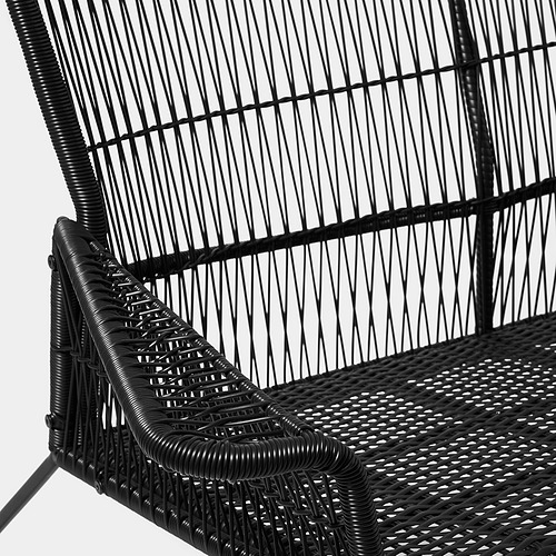 Silla de exterior de mimbre negro, intrincado patrón de tejido, robusto marco de metal.