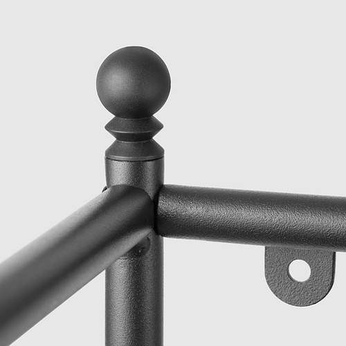 Primer plano de un robusto accesorio de metal negro mate, que muestra una parte superior decorativa redonda, una unión robusta y una placa de metal adjunta con orificio.