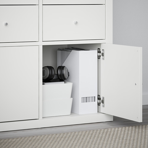 Mueble de almacenaje KALLAX con cajón abierto que muestra los objetos organizados: pesos, cajas.