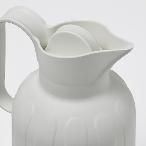Primer plano de un elegante matraz de vacío blanco con curvas suaves y asa segura.