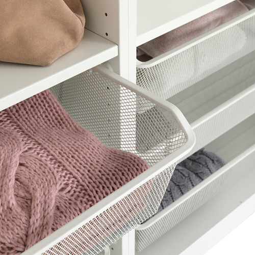 Mueble de almacenaje blanco con cesta de malla que muestra manta texturizada. El diseño de malla ofrece transpirabilidad y fácil visibilidad del contenido.