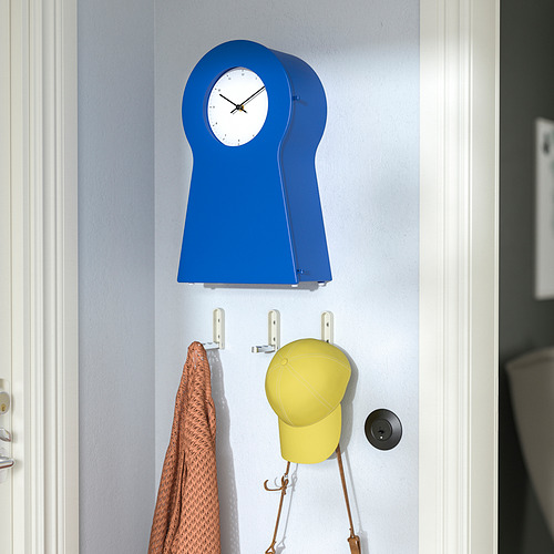 Un reloj de pared azul cuelga sobre ganchos con un sombrero y una toalla.
