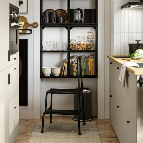 Cocina moderna con estantes abiertos, comida organizada y un taburete.