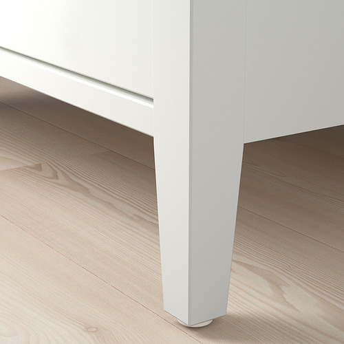 Mesa de centro blanca minimalista con elegante tapa de cristal y robustas patas de madera.