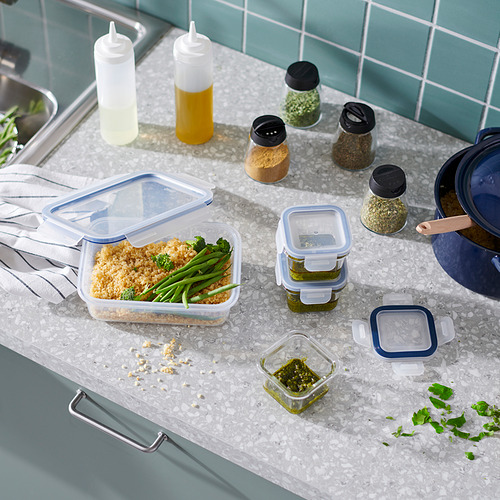 Encimera de cocina con varios recipientes de comida, botellas y una sartén; Envases IKEA 365+ en color azul, forma cuadrada.