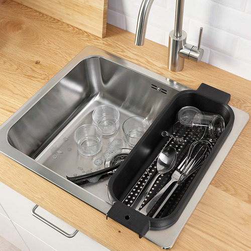 Fregadero de acero inoxidable con encimera de madera y bandeja de desagüe para vasos y utensilios.