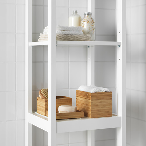 Estantes blancos de baño con toallas cuidadosamente apiladas y cajas de bambú, una de las cuales contiene algodón.