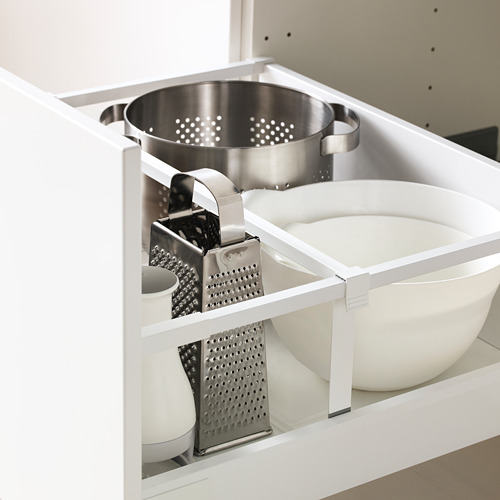Un armario de cocina blanco con un estante que contiene un colador, un rallador y un tazón. El cajón está diseñado para deslizarse suavemente hacia afuera por completo para facilitar el acceso.