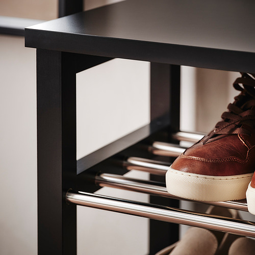 Zapatero moderno con zapatillas marrones, de madera maciza y barras metálicas, que muestra calidad y organización.