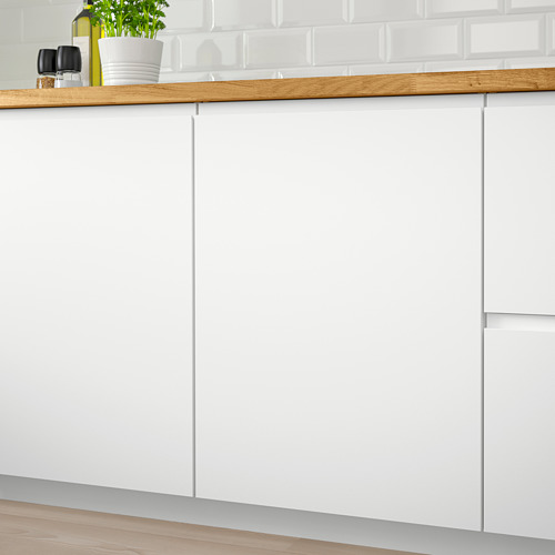 Armarios de cocina blancos con tiradores minimalistas e integrados. Encimera de madera con planta verde y botellas. Diseño limpio y moderno.