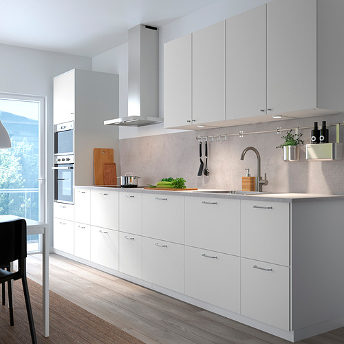 Modern white VALLSTENA kitchen with sleek cabinets, stainless sink & appliances, wooden floor, by large window.