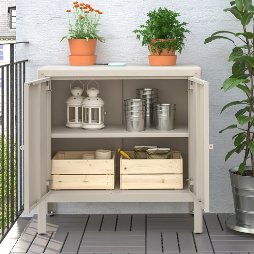 Gabinete de almacenamiento de balcón con plantas en macetas, linternas y herramientas.