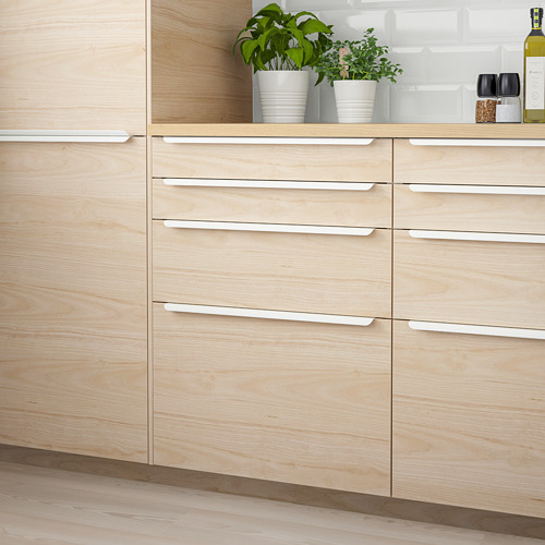 Modern kitchen with light wood ASKERSUND drawers. Stain-resistant, melamine faux wood. Six vertical drawers near potted plants.