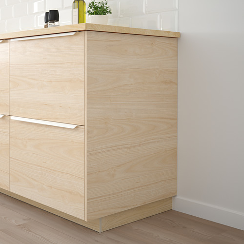Gabinetes de cocina de madera clara ASKERSUND, diseño elegante y moderno, más altos que los artículos cercanos.