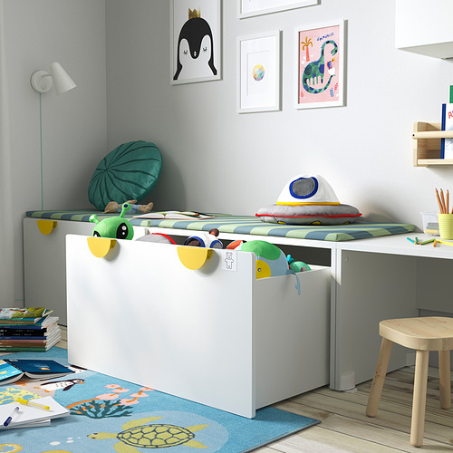 Habitación para niños con banco de almacenamiento blanco para juguetes, almohadas coloridas y arte de pared.