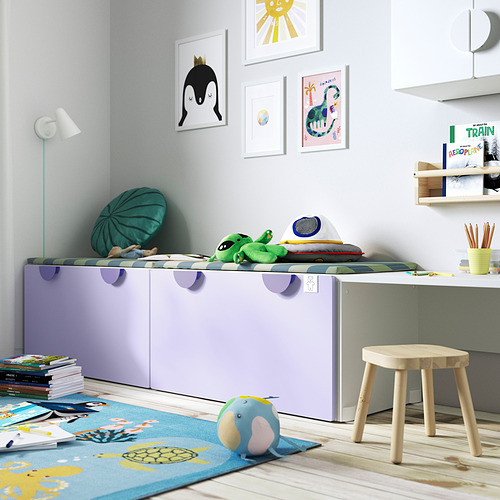 Habitación infantil con caja de juguetes SMÅSTAD, morado claro, rectangular, guarda los juguetes de forma ordenada. Es más grande que el taburete a su lado, cabe debajo del arte de la pared colgante.