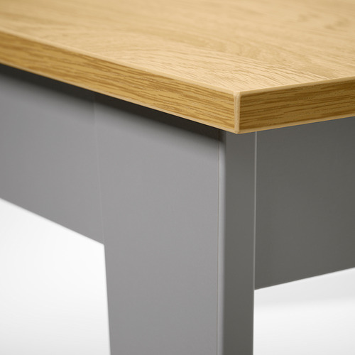 Primer plano del borde de las mesas modernas: superficie de madera lisa y base gris duradera.