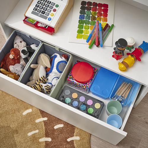 Cajón de almacenamiento para niños organizado: animales de peluche, juguetes, materiales de arte y herramientas de pintura ordenadamente en secciones.
