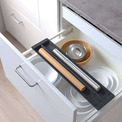 Cajón de cocina abierto con organizador deslizante que sujeta platos, rodillo y tazones. El organizador crea almacenamiento adicional y amortigua el sonido.
