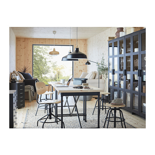 Moderna oficina industrial en casa con sillas giratorias negras KULLABERG, amplio escritorio y lámparas negras.