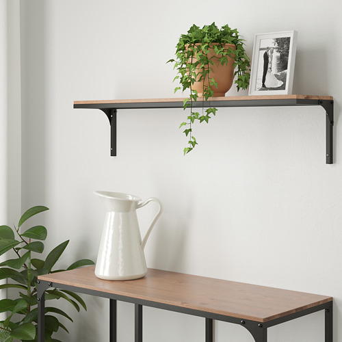 Estantería FJÄLLBO con planta y foto, banco debajo con jarra.