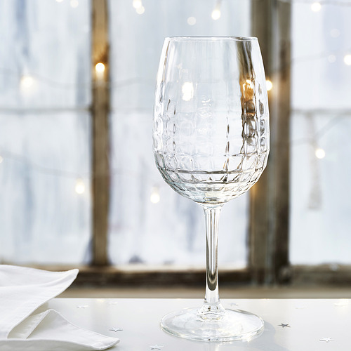 Elegante copa de vino con diseño facetado sobre una mesa prístina, que refleja alta calidad y sofisticación.