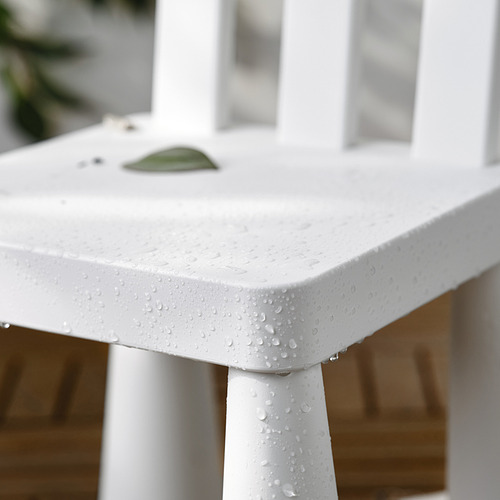 Mesa infantil blanca con gotas de agua, pequeña hoja verde en la parte superior.