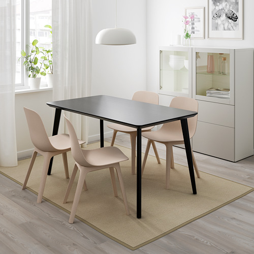 Comedor LISABO de IKEA con mesa negro-marrón, sillas grises, alfombra beige, armario blanco y ventana con cortinas transparentes.