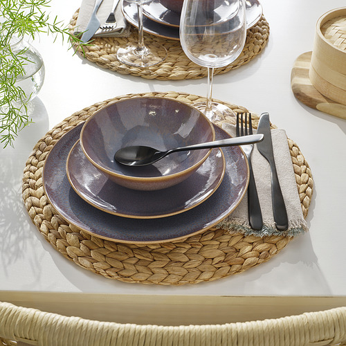 Mesa con mantel tejido, platos rústicos, cristalería, cubiertos y servilleta de tela.