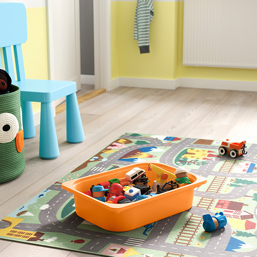 Caja de juguetes naranja TROFAST con coches, bloques, en alfombra de juego del pueblo.