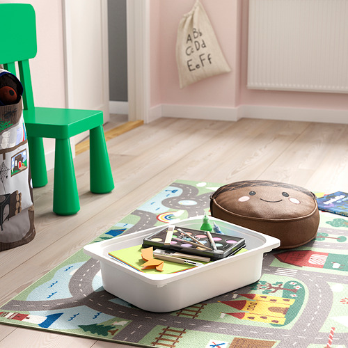 Contenedor de almacenamiento de plástico para niños, silla verde, almohada de piso sobre alfombra de juego colorida.