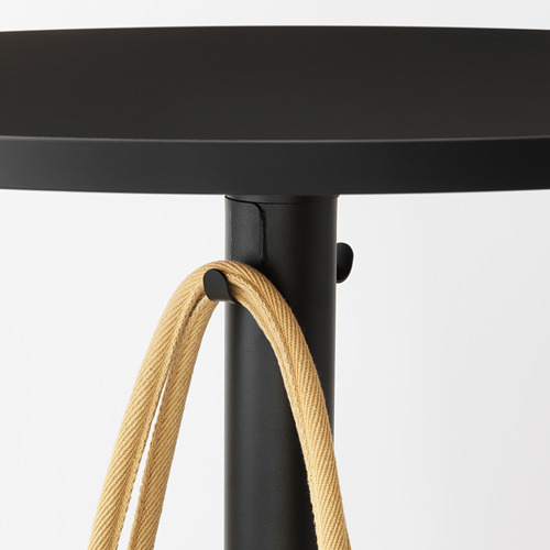 Mesa de bar redonda negra con ganchos de cuerda para colgar objetos.