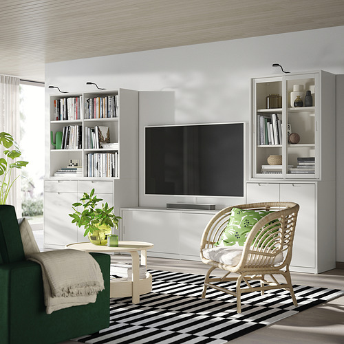 Moderno conjunto de sala de estar TONSTAD de color blanquecino con elegante mueble de TV, estanterías, silla de mimbre y sofá verde. Diseño luminoso y minimalista.