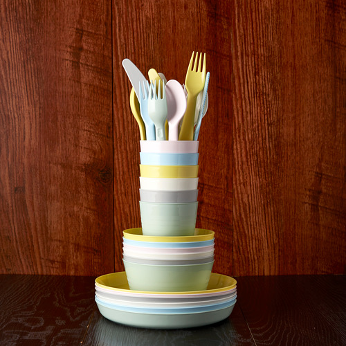 Colorido juego de vajilla para niños con tazas, tazones y cubiertos en un soporte de madera. Perfecto para edades de 3+.