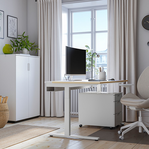 Se muestra el escritorio ajustable blanco MITTZON, con monitor, silla y almacenamiento. Instalación de oficina en casa moderna, espaciosa y bien iluminada.