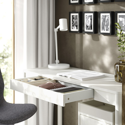 Escritorio TONSTAD blanco, estrecho y elegante, organizado con cajón abierto, libros, lámpara y planta.
