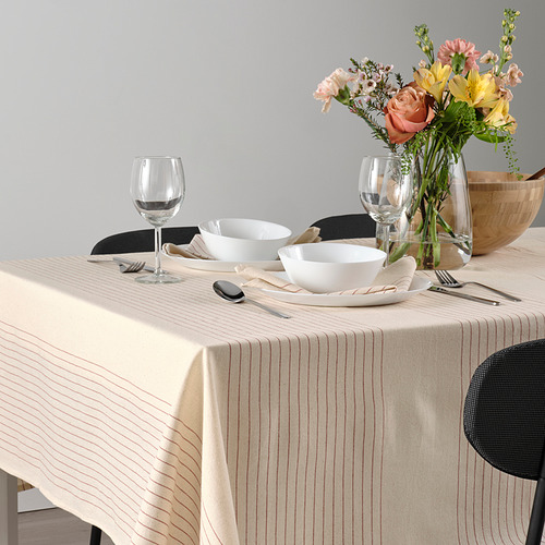 Elegante mesa con mantel a rayas, cuencos blancos, cubiertos, copas de vino y centro de mesa floral.