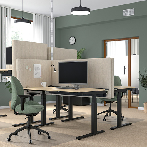 Moderna oficina con pantallas MITTZON beige, sillas verdes, plantas y luces.