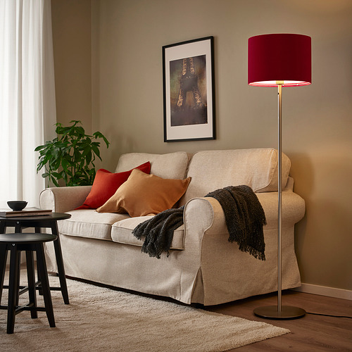 Lámpara de terciopelo rojo junto a sofá beige, luz cálida. Acorté el eliminando al lado para que se ajustara al límite de 150 caracteres.