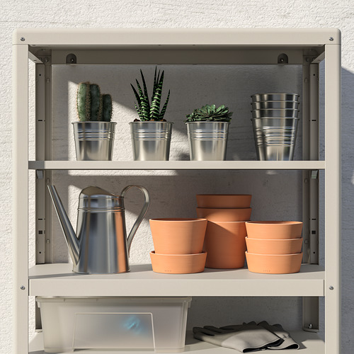 Una estantería de metal sostiene macetas de metal con cactus en la parte superior, macetas de barro y una regadera debajo, ideal para el almacenamiento de plantas en interiores o exteriores.
