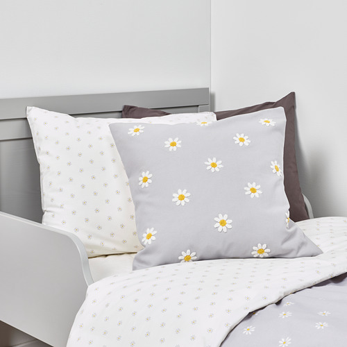 Juego de cama con estampado de margaritas con cojín capitoné y sábanas florales.
