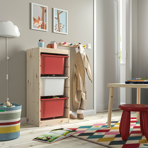 Área de juegos para niños con almacenamiento TROFAST, cajas rojas, madera, alfombra colorida. Bajo, luminoso, organizado.