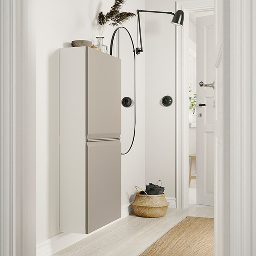 Modernos muebles de almacenaje en blanco y beige con asas y lámpara negras, cesta tejida en el suelo.