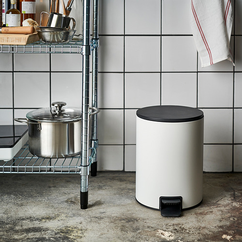 Cubo de basura blanco con tapa negra y pedal en cocina.