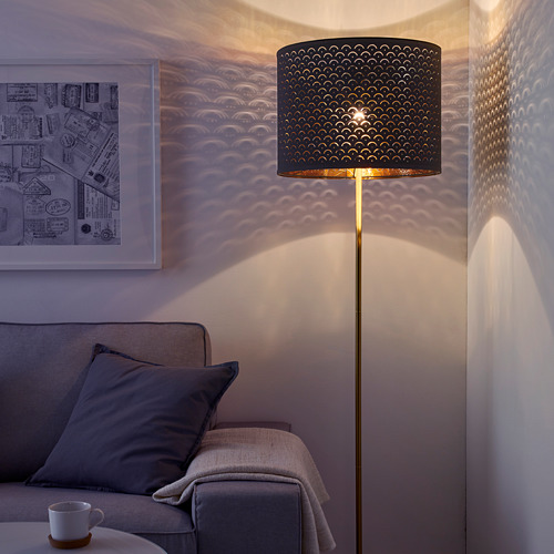 La lámpara NYMÖ proyecta una luz estampada en la pared, el sofá y la mesa.